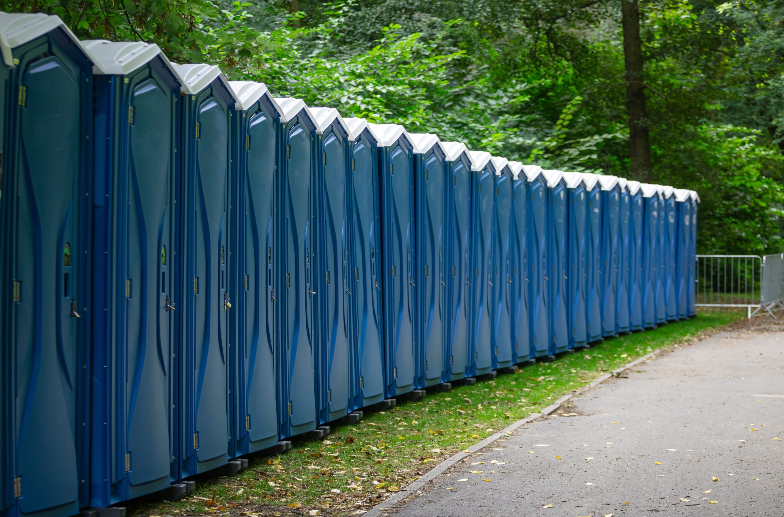 Bio public toilets at a park. Locked, portable chemical lavatories that provide privacy and hygiene. Nature background.